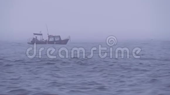 在多云多雾天气下与游客或渔民在公海孤独的摩托艇视频的预览图