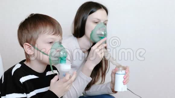 使用雾化器和吸入器进行治疗女人和男孩通过吸入器面罩吸入侧视视频的预览图