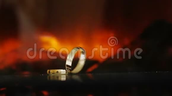 火的背景上的金色戒指黑黑的一个卷到另一个视频的预览图