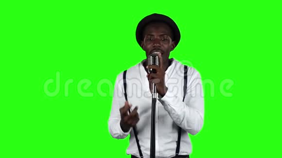 歌手唱成复古麦克风旋转和跳舞围绕他绿色屏幕慢动作视频的预览图