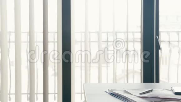 办公室大窗户旁边桌子上的现代笔记本电脑视频的预览图
