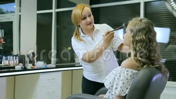 专业化妆师用刷子清洁金发模特的脸视频的预览图
