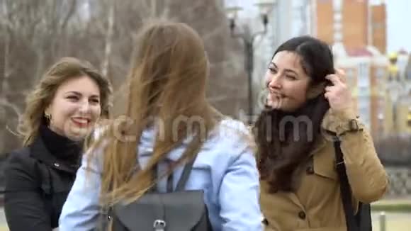 女孩的友谊三个年轻漂亮的女孩在街上聊天他们很开心女孩们很高兴见面视频的预览图