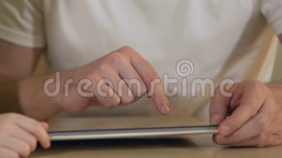 父女在平板电脑上搜索新的教育应用程序视频的预览图