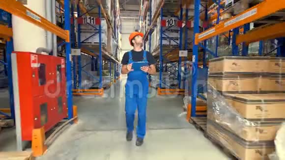 一个穿制服的工人沿着仓库走廊散步视频的预览图