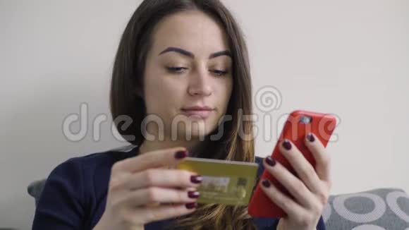 躺在床上用手机网上购物的年轻女子视频的预览图