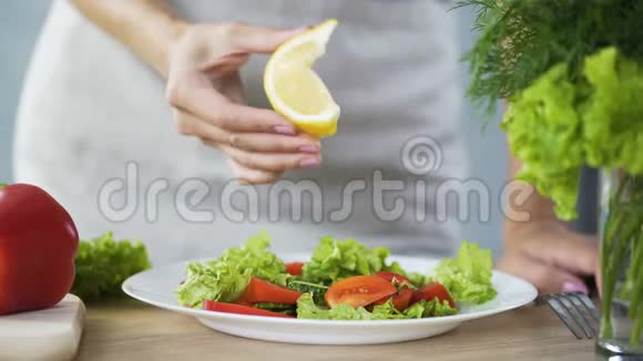 家庭主妇用柠檬汁洒蔬菜沙拉富含维生素的食物视频的预览图
