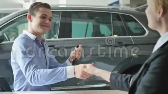 快乐的人在汽车沙龙里得到汽车钥匙视频的预览图