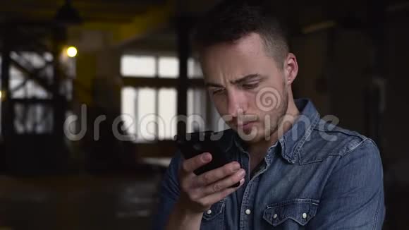 一个年轻人在一个漆黑的大厅里用电话视频的预览图
