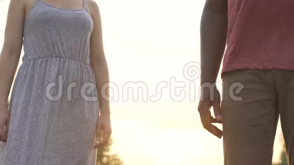 男朋友和女朋友在夕阳的背景下紧紧地握手视频的预览图