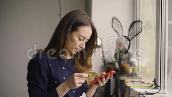 家庭技术和互联网概念拥有智能手机和信用卡的女性在家视频的预览图