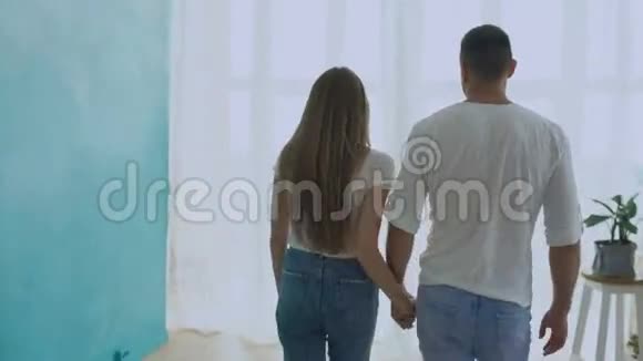 steadicam拍摄的情侣拥抱走到窗前拉开窗帘在新家亲吻对方视频的预览图