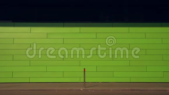 女人沿着绿色的墙走视频的预览图