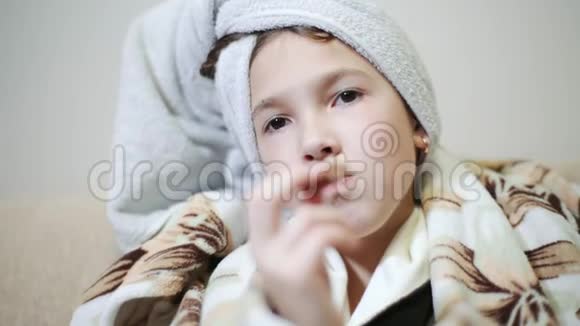 女孩用毛巾把自己裹在头上用毯子把自己裹在身上吃巧克力女孩在吃东西视频的预览图