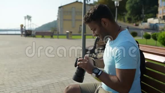 可爱的印度男人坐在户外用照相机视频的预览图