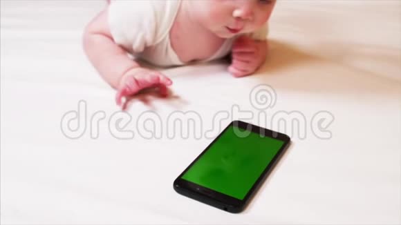 可爱的6个月大男孩玩智能手机的特写镜头视频的预览图