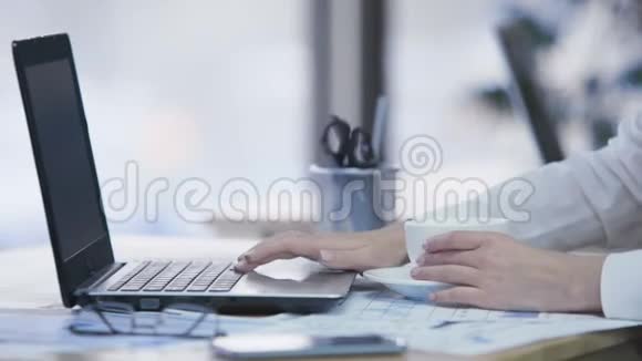商务女士在笔记本电脑上查看电子邮件喝咖啡勤劳的女人视频的预览图