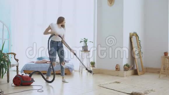 年轻女子在家里用吸尘器打扫房间跳舞唱歌视频的预览图