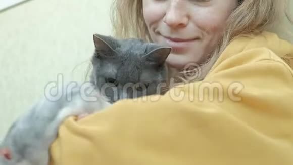 一个穿着黄色衣服的年轻女人抱着一只灰色的猫一只老鼠在女人身边跑来跑去一个熟人一个人视频的预览图