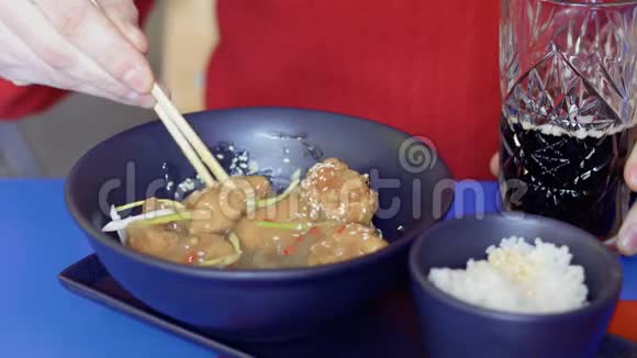 在餐馆里男人吃韩式鸡肉和芝麻酱视频的预览图