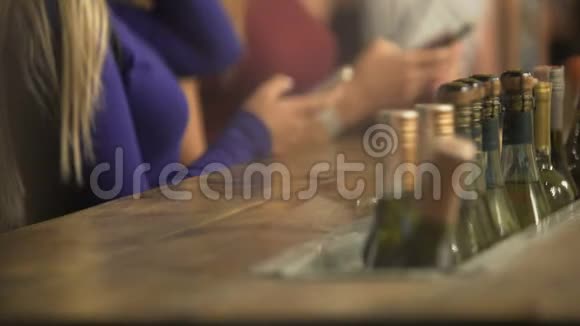 年轻女性在酒吧柜台等待饮料使用小玩意随音乐跳舞视频的预览图