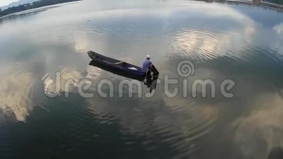 下午一个人在湖面上划着他的木船轮廓视频的预览图