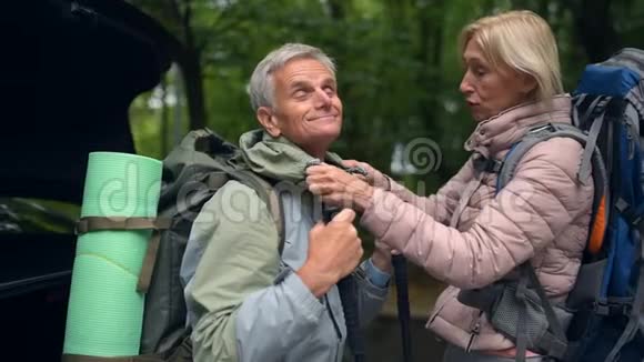 令人愉快的老年夫妇准备在森林里进行一次短途旅行视频的预览图