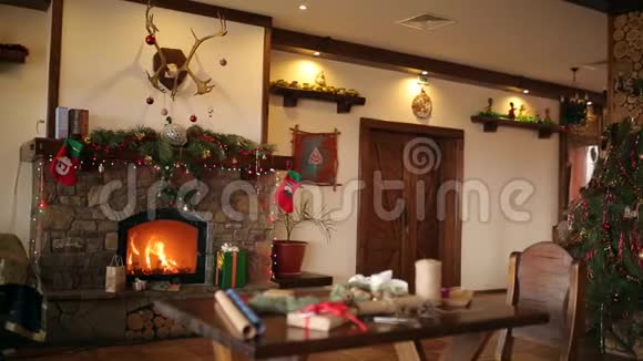 在圣诞前夜壁炉里燃烧着花环花环长袜和礼物呈现和视频的预览图