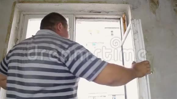 那个人正用手拆除旧窗户视频的预览图