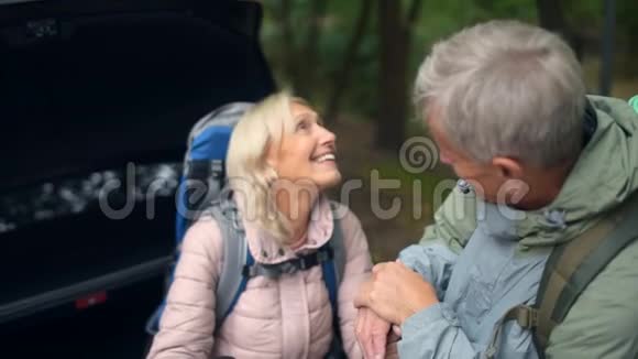 快乐的一对老年游客在森林里的汽车附近闲逛视频的预览图