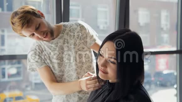 专业美发师发型师在专业美发店梳理女性客户头发美容和理发的概念视频的预览图