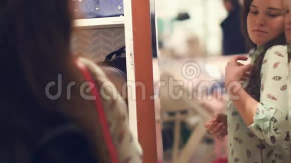 商店里的一位年轻女子正在挑选一个袋子站在商店的镜子旁视频的预览图