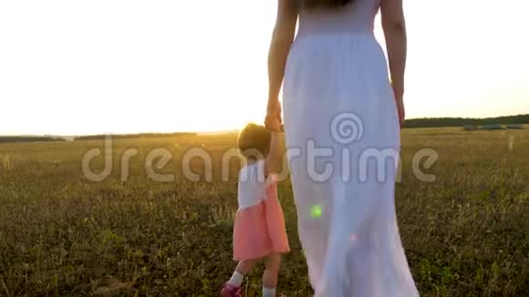 小宝宝在灿烂的夕阳中牵着妈妈的手向前走视频的预览图