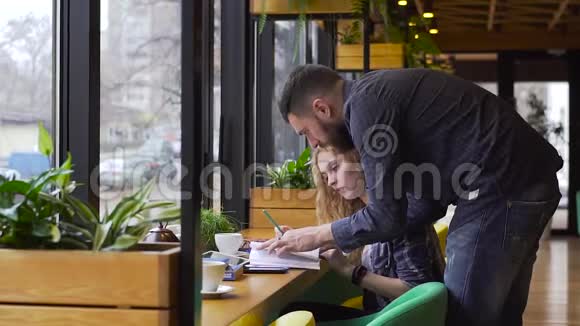 男人和女孩在咖啡馆里慢慢地准备考试视频的预览图