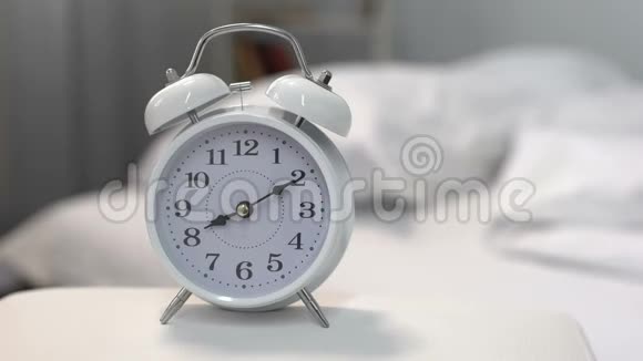 靠近床的床头桌上有白色闹钟时间管理睡眠时间视频的预览图