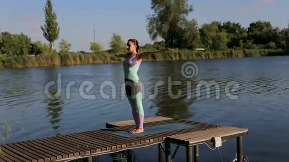 运动女孩早上在湖边做瑜伽视频的预览图