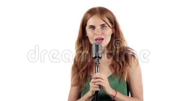 带雀斑的女孩用复古麦克风唱歌白色背景慢动作视频的预览图