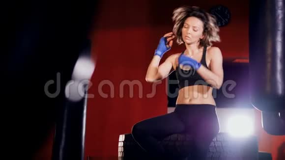 一个穿着黑色衣服的年轻女性在拳击室里做伸展运动4K视频的预览图