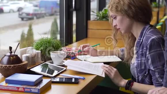 一个年轻人帮助一个女孩在咖啡馆学习视频的预览图