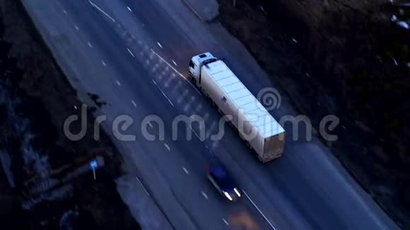 日落时乘坐巨大立交桥的卡车的鸟瞰图视频的预览图