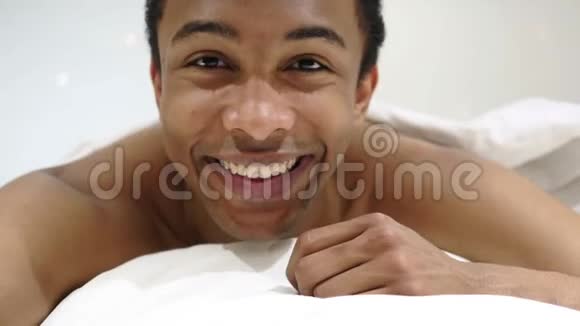 躺在床上的非洲人在线视频聊天的网络摄像头视图视频的预览图