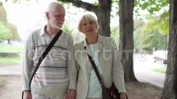 老两口在公园散步退休后积极的现代生活家庭一起享受时光视频的预览图