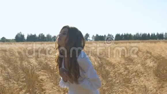 那女人高兴地叫喊着高兴地用麦子在田野上视频的预览图