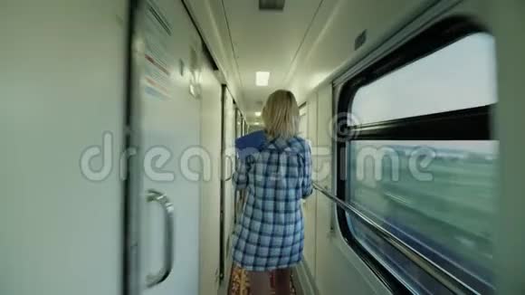 stadicam射击一个拿着毛巾的女人正沿着一列客运列车走着凌晨在路上后方视频的预览图