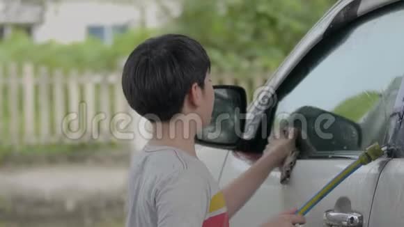 亚洲可爱男孩微笑着洗车视频的预览图
