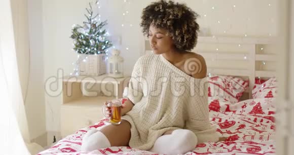 年轻女子坐在床上喝茶视频的预览图