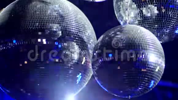 旋转镜球在一个俱乐部反射蓝光近距离拍摄视频的预览图