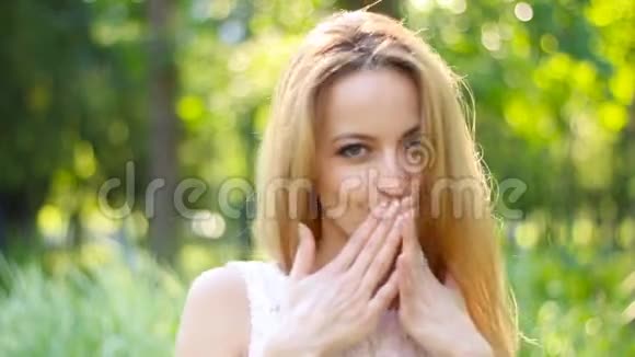 空中之吻微笑的金发女人在夏天公园炫耀她那长长的茂盛的头发视频的预览图