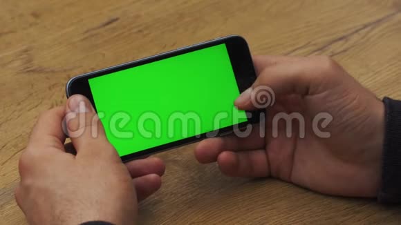 人使用水平智能手机与绿色屏幕男人用手机手的特写镜头铬钥匙关门视频的预览图