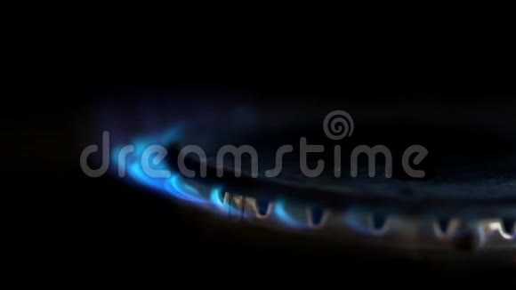 在一个黑暗的厨房里煤气炉上点燃了蓝色的火焰视频的预览图